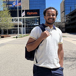 Robera Legese stands on the Optum campus with the company logo showing on the building entrance in the background