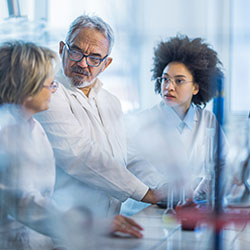 Three scientists talking in a lab