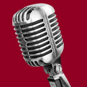 a silver microphone is shown before a bright maroon background