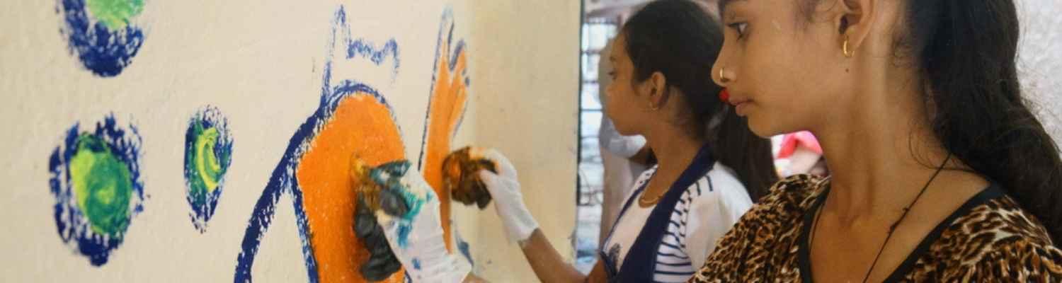 Two young people painting a mural