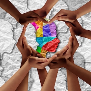 A group of hands making a heart shape around a multicolored silhouette of a head